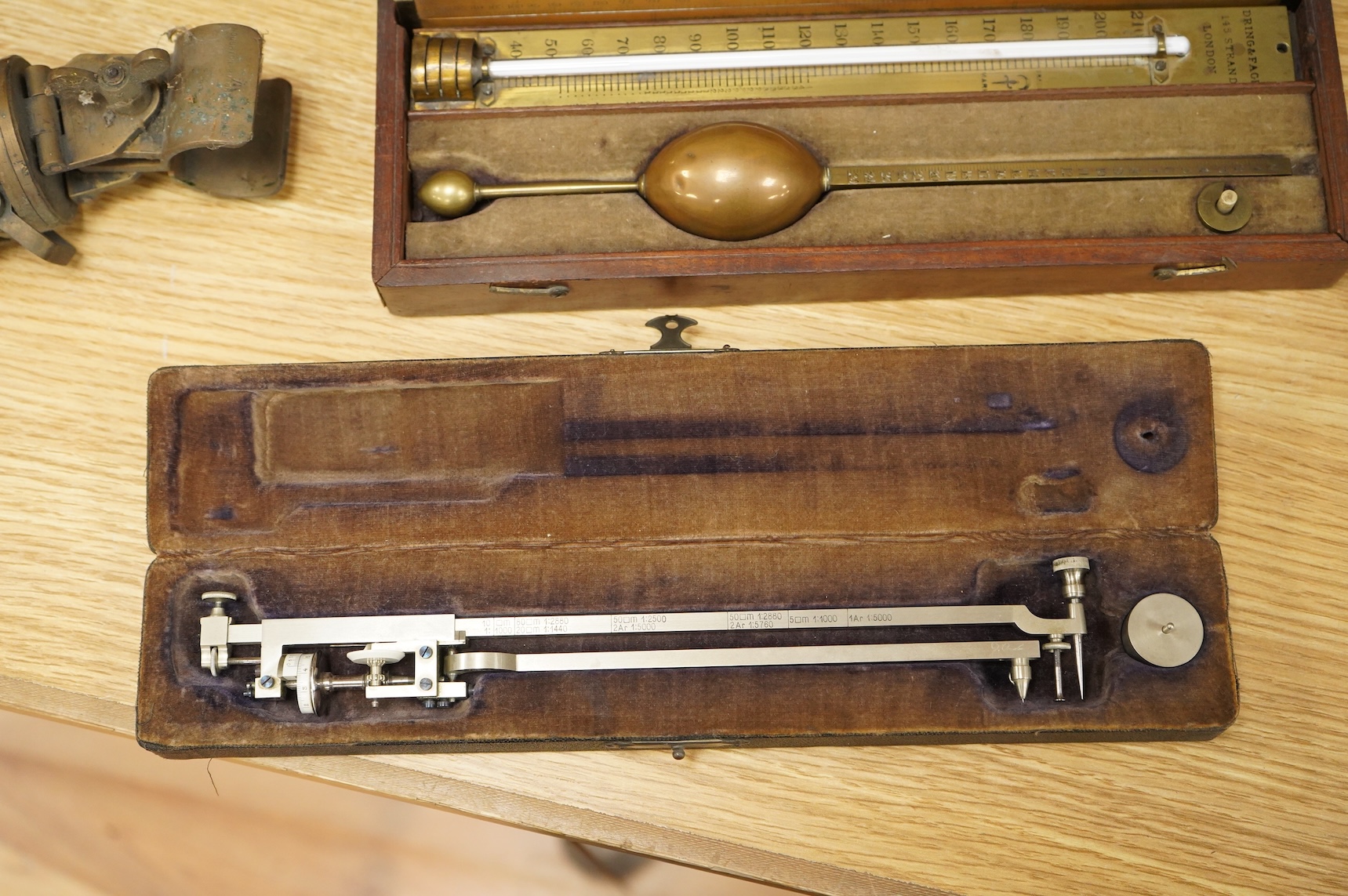 Five scientific instruments, comprising; a rolling parallel rule, pine boxed, 48cm wide; an early 20th century boxwood and brass Alidade, by J. Hicks, 8, 9 & 10, Hatton Garden, leather cased; an oak and brass tripod, sta
